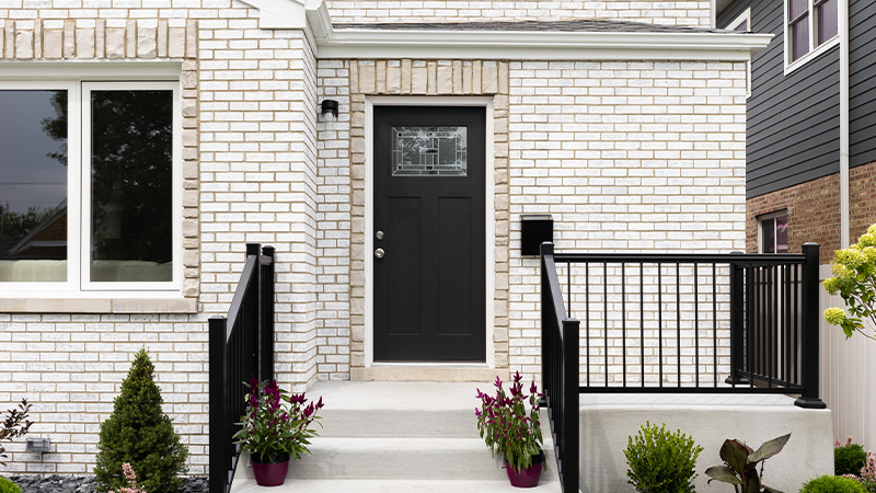 modern home entrance with black door surrounded by bricks and plants showcasing welcoming curb appeal for 11 design ideas
