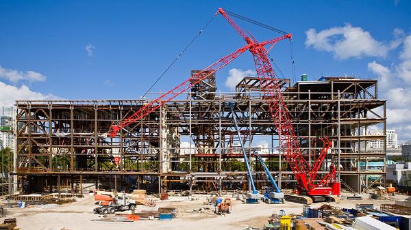 construction worker laying bricks on a wall with focus on building eight layers of bricks using a trowel and gloves